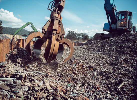 Greifkran greift nach Schrott Platz