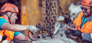 Mitarbeiter Halle Material wir an Kran befestigt